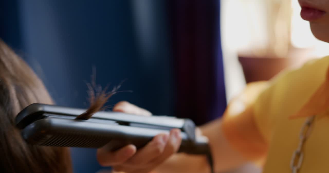 Glätteisen zieht durch eine Haarsträhne